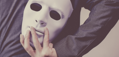 Businessman holding mask behind his back