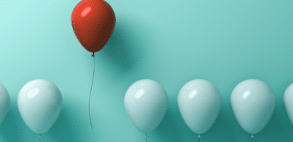 One red balloon floats above a few other green balloons